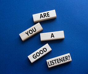 Listening skills symbol. Wooden blocks with words Are you a good Listener. Beautiful deep blue...