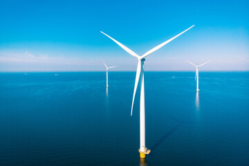 Wind mill turbines with a blue sky, windmill park in the ocean aerial view with wind turbine Flevoland Netherlands Ijsselmeer. Green Energy production in the Netherlands