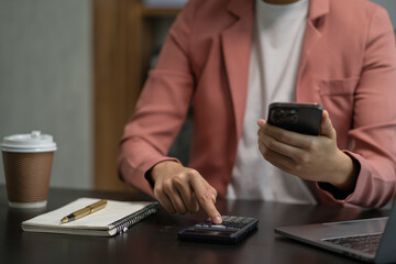 Investors have to calculate investment cost calculator and hold a mobile phone in hand.