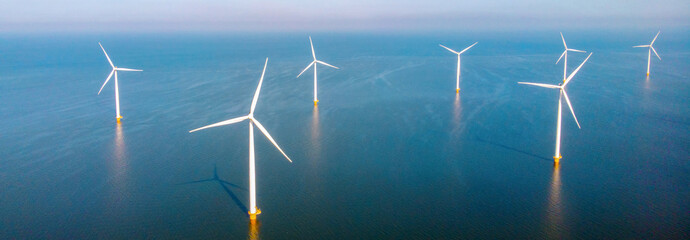 drone view at Windmill park with clouds and a blue sky, windmill park in the ocean aerial view with...
