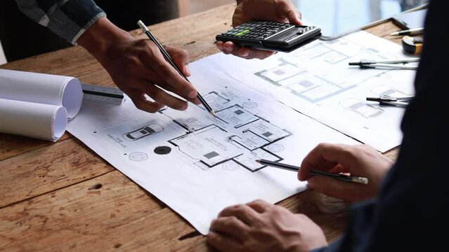 The home design architects are reviewing the house plan draft, the project commissioned by the client, and the custom design before delivery. Interior design and decoration ideas.