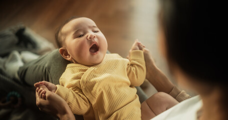 Portrait of a Cute Asian Baby Laughing, Resting on His Mother's Lap and Enjoying a Bonding Time...