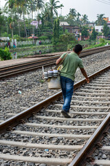14-08-2023, Kolkata, West Bengal, India: A hawker or seller walking on railway track. Concept of...