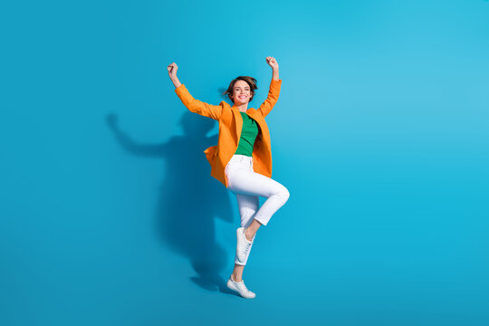 Full length photo of overjoyed positive lucky lady wear trendy clothes hands fist up celebrate win isolated on blue color background