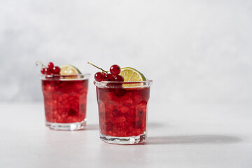 Red currant mojito in glasses with ice on white background with copy space. Refreshing berry drink