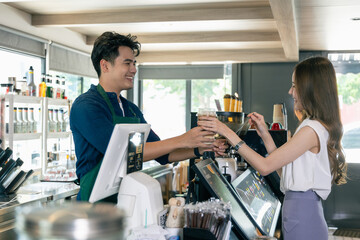 Smiling Asian Barista Proudly Serving Coffee in Coffee Shop