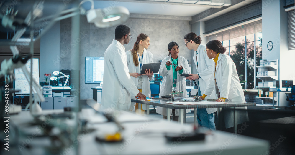 Aufkleber Young Engineers Working in Company Facility Lab: Group of International Multiethnic Lab Specialists Gathering Around a Table to Discuss Blueprints and Components for a High-Tech Robotic Project