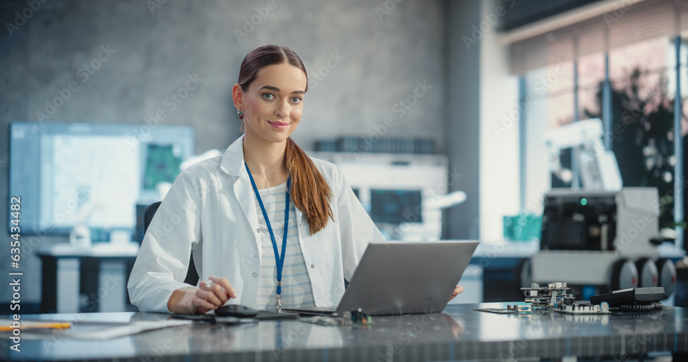 Aufkleber Portrait of Caucasian Young Female Scientist Using Laptop Computer, Looking at Camera and Smiling in a Laboratory. Confident Professional Woman Working as Lead Engineer, Monitoring Technology Projects