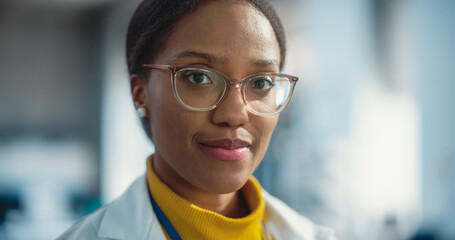 Portrait Close Up of Young Black Female Specialist Wearing Lab Coat and Glasses Smiling. Professional and Successful Woman Working as an Engineer, Developing High Technology Projects - obrazy, fototapety, plakaty