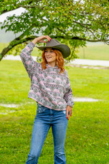 A Lovely Red Headed Country Wetern Model Poses Outdoors In A Country Setting