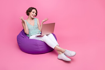 Full body photo of young girl working communicate with boos online google meet laptop user sit beanbag isolated on pink color background