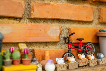 Miniature pottery kitchen utensils, handmade works arranged on the wall in the orange color.