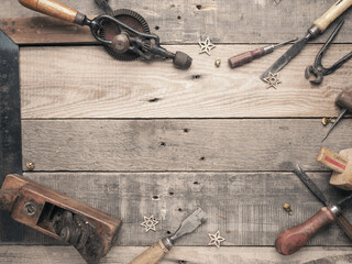 Vintage carpenter tools as a frame on a rustic wooden workbench