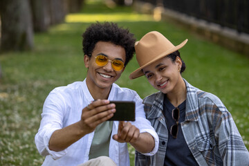 Smiling couple making selfie in the park