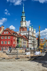 Historic tenement houses, historic town hall tower and construction machinery on the market square...