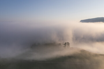 Summer aerial landscape above the foggy valley