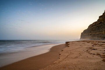 Brandung des Ozeans an der sandigen Küste der Algarve am Abend
