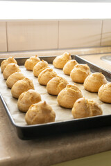 Freshly baked profiteroles on a plate. food concept. dessert. bakery.
