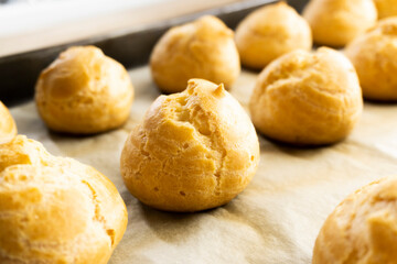 Freshly baked profiteroles on a plate. food concept. dessert. bakery.