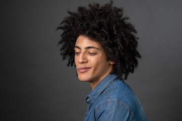 Fototapeta na wymiar Curly-haired young guy smirking and looking foxy