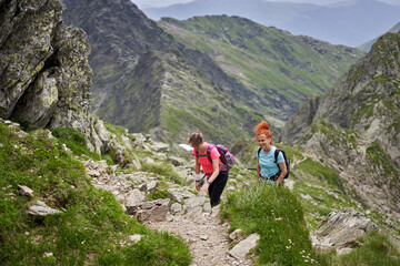 Women hiking on a trail in the rocky mountains