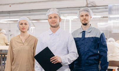 Team workers operators man and woman background food products conveyor with wheat flour. Crew of electrical mill machinery for production © Parilov