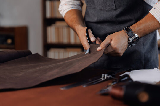 Tailor cobbler use natural brown leather, shoemaker working with skin textile in workshop