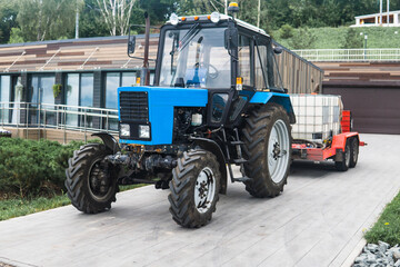 Obraz premium wheeled tractor with irrigation tanks on a trailer for maintenance of urban green spaces