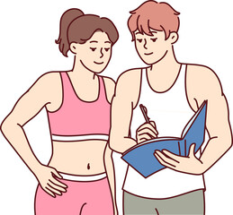 Man fitness trainer advises girl, drawing up training plan to achieve new sports heights