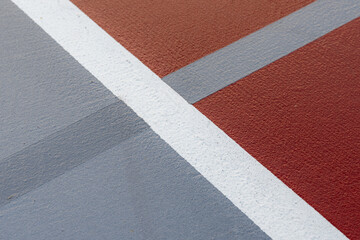 Fototapeta premium Wet red tennis court with white lines combined with gray pickleball lines