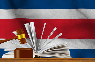 Judicial gavel on the background of an open book and the flag of Costa Rica.