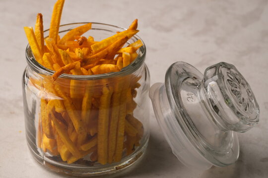 taro chips on glass bowl. made from taro which is chopped long, seasoned, then fried. stik keripik talas. 