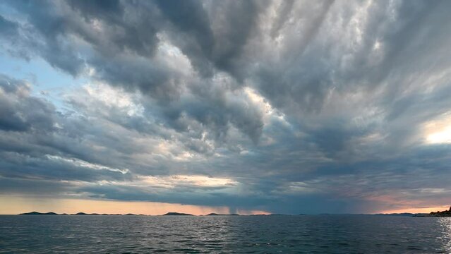 Time lapse of Dramatic dark clouds over the sea. Rain clouds at sunset.