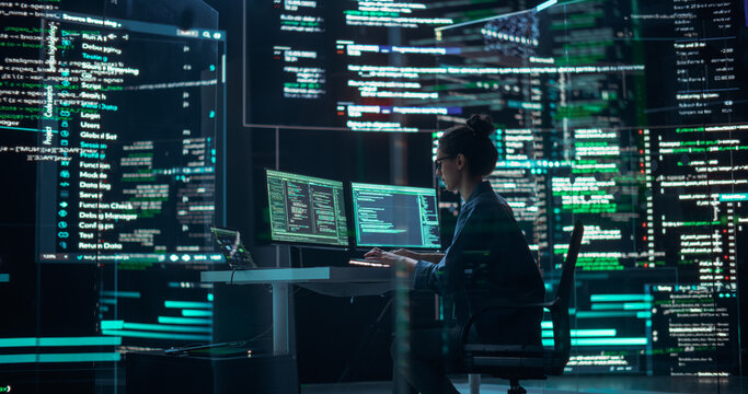 Professional Female Programmer Working in a Monitoring Control Room, Surrounded by Big Screens Displaying Lines of Programming Language Code. Portrait of Woman Creating a Software and Coding