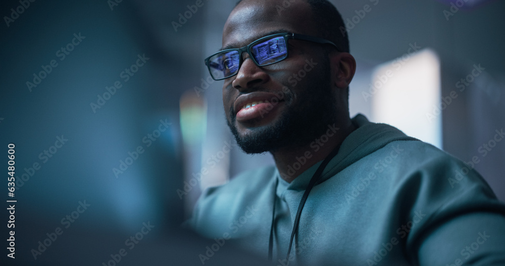Aufkleber Black Male Developer Smiling Happily After Successfully Typing on Computer a Functioning Software Code. Professional Programmer Creating a Mobile App, Screen Display Reflected on his Glasses