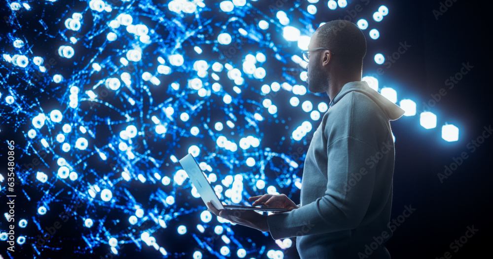 Aufkleber Portrait of Young Black Man Working on Laptop Computer, Looking at Big Digital Screen Displaying Neural Network Visualisation in 3D. Professional Data Specialist Analysing User Information Concept.