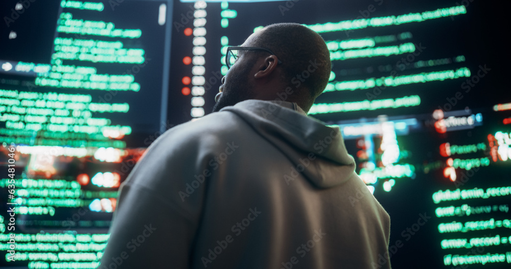 Poster Close Up Back View of Young Black Man Looking at Big Digital Screens Glitching While Displaying Code Lines. Professional Hacker Breaking Through Cybersecurity Protection System, Changing Code.