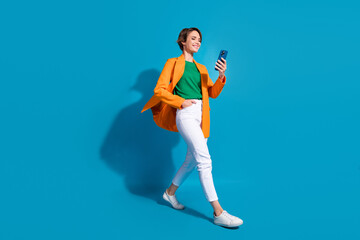 Full body size cadre of young optimistic project manager nice woman student communicating phone chat isolated on blue color background