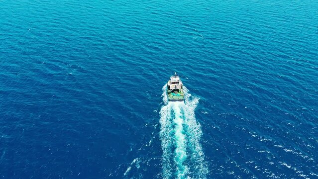 Fishing ship trawler in cruising open Aegean sea, aerial wide shot