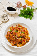 crispy orange cauliflower florets in white bowl