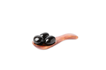 Tasty black olives in a wooden spoon with leaves isolated on white background. Vegan. Design.