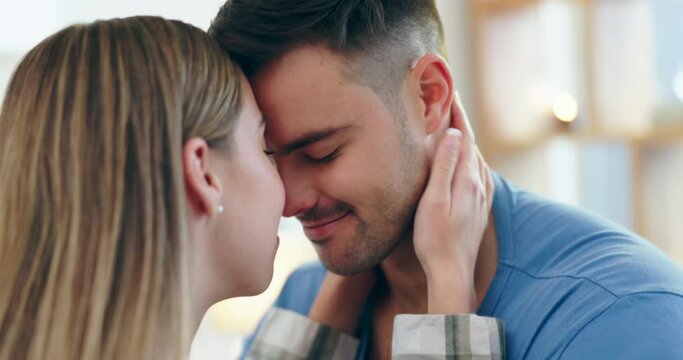 Happy, love and couple with a romantic moment in the living room of their apartment together. Happiness, bonding and young man and woman with nose kisses for care and affection in lounge at home.