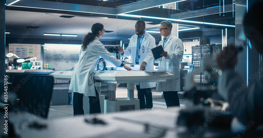 Leinwandbilder Industrial Robotics Specialists Working on a Mobile Robot, Using a Tablet Computer. Male Engineer In Lab Coat Discussing an Automated AI Robotic Delivery Assistant with His Young Team