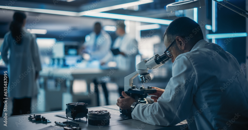 Aufkleber Scientist Using a Modern Digital Microscope in a Research and Development Facility. On Blurred Background Diverse Team of Industrial Specialists Working on Remotely Controlled Mobility Robot.