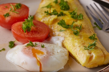 Smoked Haddock with poached egg and tomatoes and garnished with parsley.