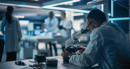 Scientist Using a Modern Digital Microscope in a Research and Development Facility. On Blurred...