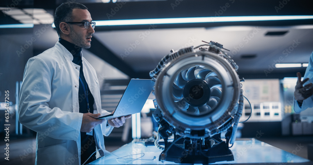 Aufkleber Group of Engineers Collaborate on a New Type of a Gas Turbine Engine. Male Project Leader Holding a Laptop Computer and Explaining the Innovative Technology in Scientific Technology Lab