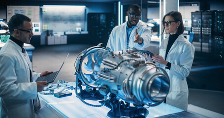 Airplane Engine Engineer and Scientist Work on a Futuristic Turbine Motor, Standing with Tablet...