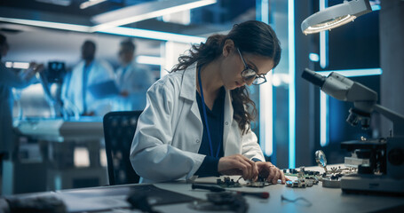 Proffesional Female Engineer Working on Electronic Circuit Boards. On Blurred Background Industrial...