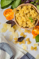 Rasta bantki pasta in a bowl with vegetables and herbs on a light background, top view..